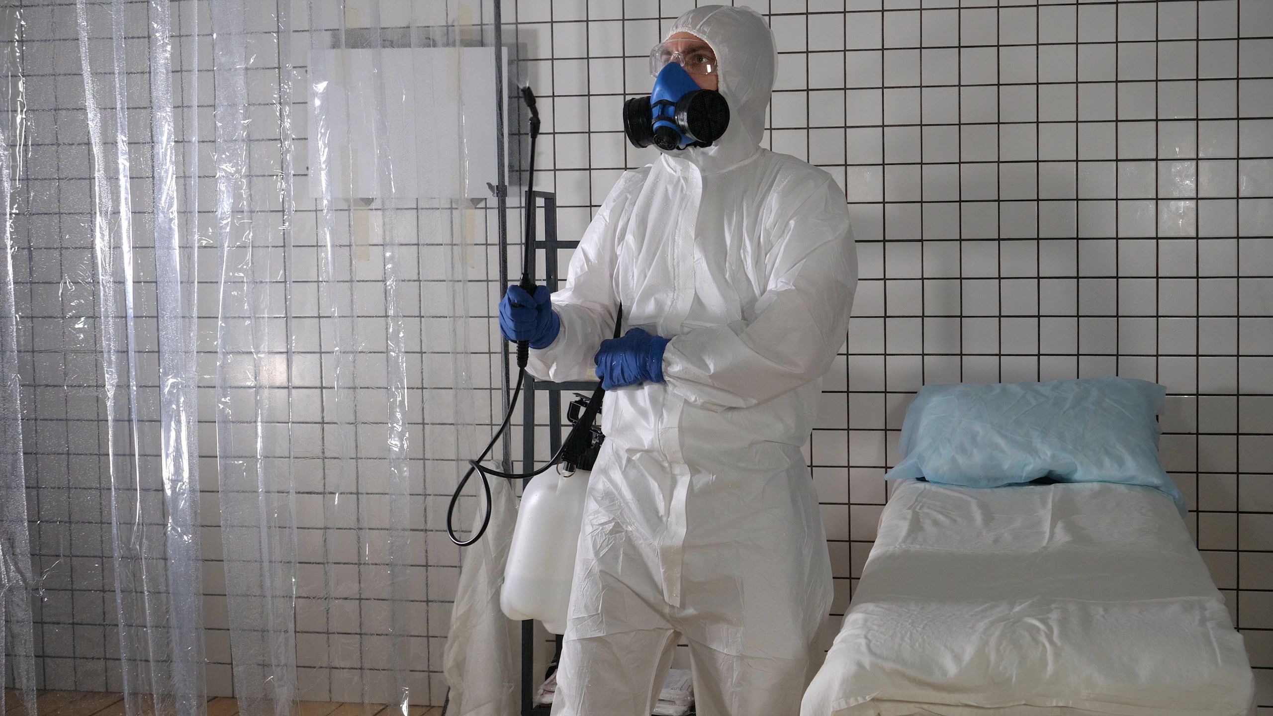 Worker spraying disinfectant in an interior facility