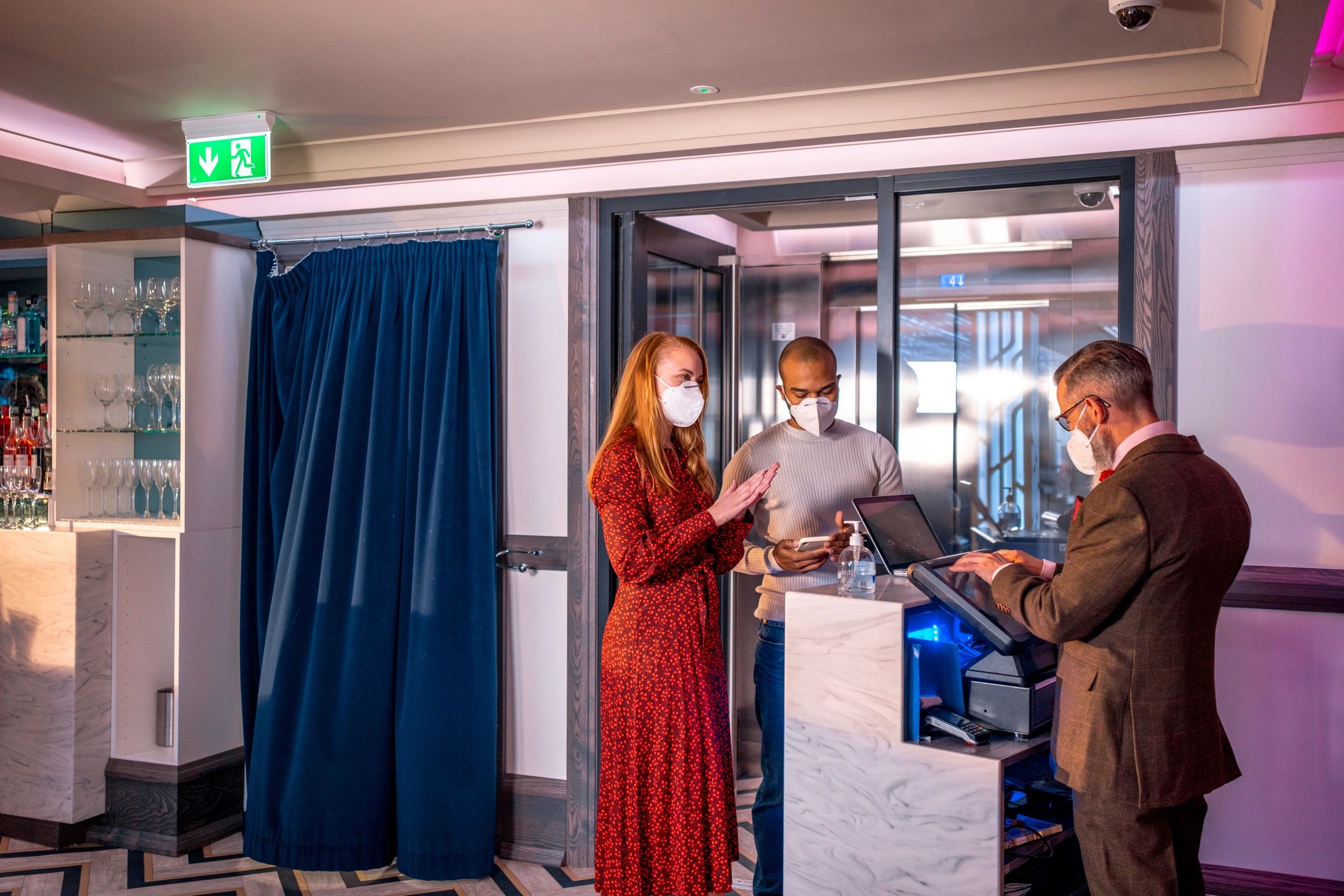 People sanitizing hands before entering a commercial space