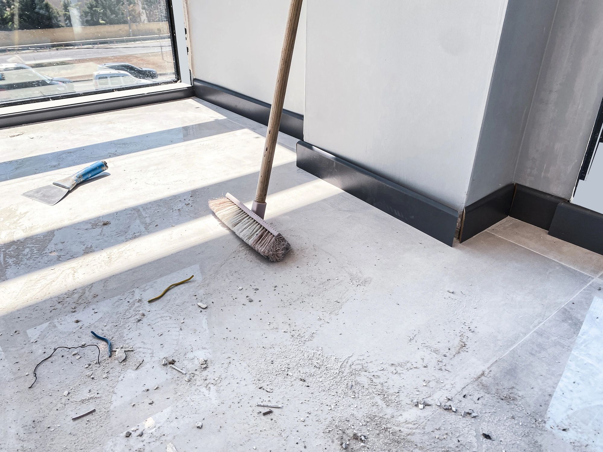 Broom Sweeping Dust and Debris on a Tiled Floor After Home Renovation